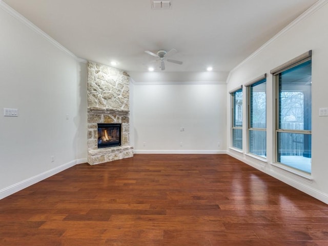 unfurnished living room with dark hardwood / wood-style flooring, a stone fireplace, and ornamental molding