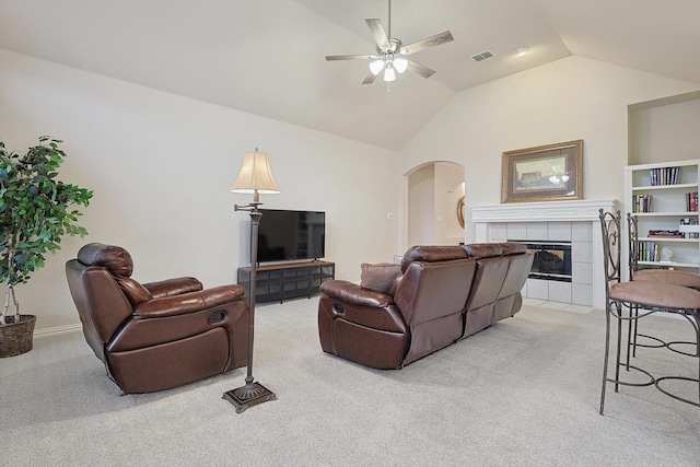 carpeted living room with a fireplace, ceiling fan, and vaulted ceiling