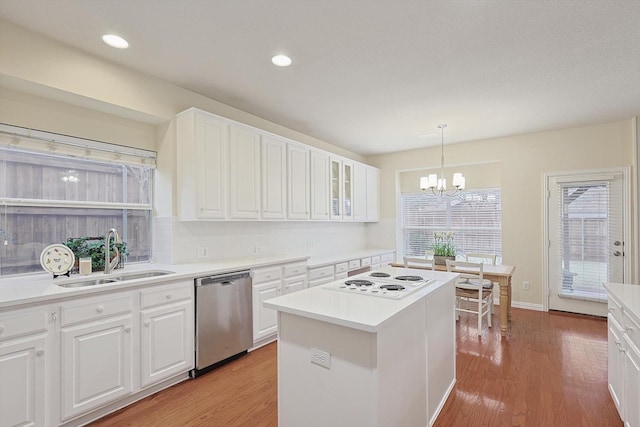 kitchen featuring white electric cooktop, decorative light fixtures, white cabinetry, sink, and stainless steel dishwasher