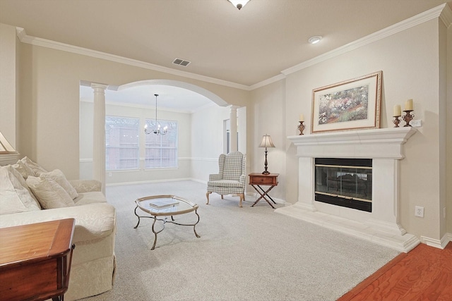 living room with ornamental molding, a high end fireplace, decorative columns, and carpet