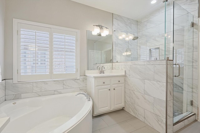 bathroom featuring vanity, independent shower and bath, tile patterned flooring, and tile walls