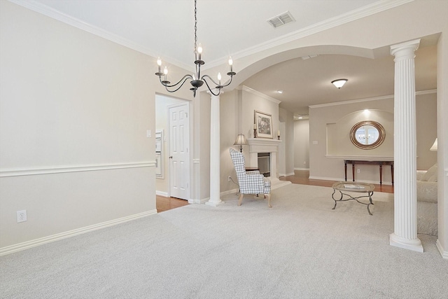 unfurnished room with light carpet, ornamental molding, a chandelier, and ornate columns