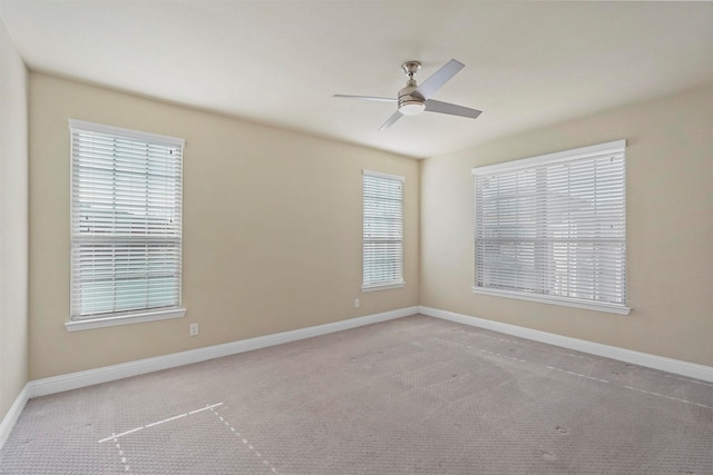 carpeted spare room featuring ceiling fan