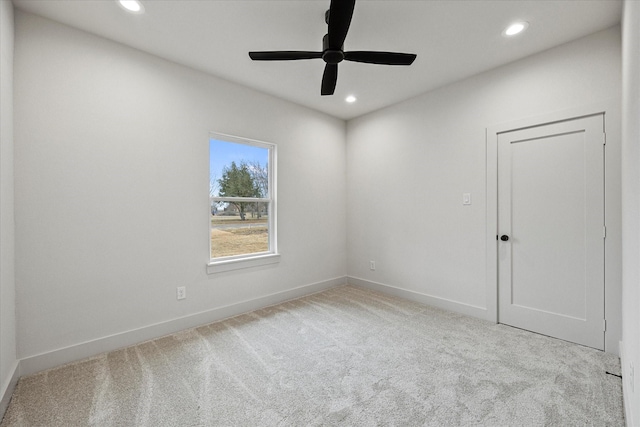 unfurnished room with light colored carpet and ceiling fan