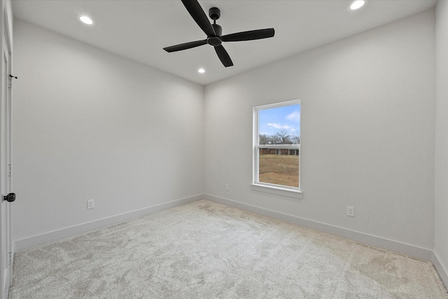 empty room featuring ceiling fan and light colored carpet