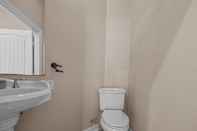 half bath featuring a sink and toilet