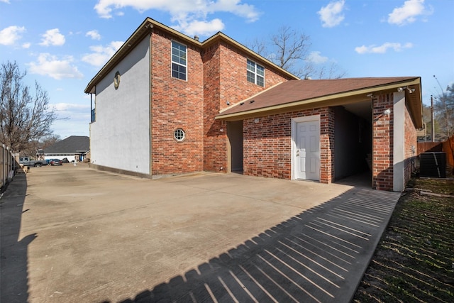 back of property with a patio area, brick siding, cooling unit, and fence