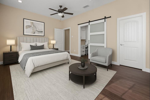 bedroom with dark wood-style flooring, baseboards, visible vents, and a barn door
