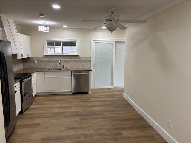 kitchen with sink, appliances with stainless steel finishes, dark hardwood / wood-style flooring, white cabinets, and backsplash