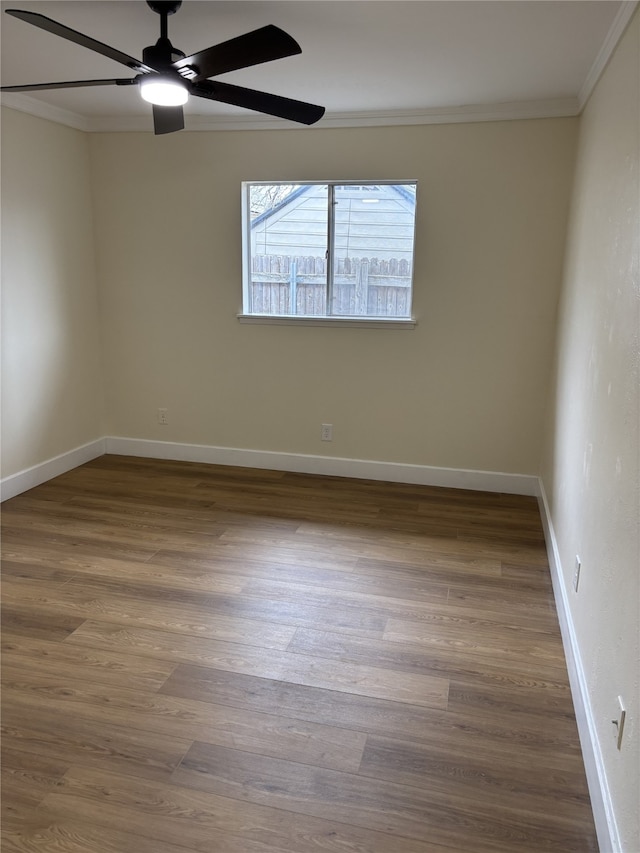 spare room with hardwood / wood-style flooring, ornamental molding, and ceiling fan