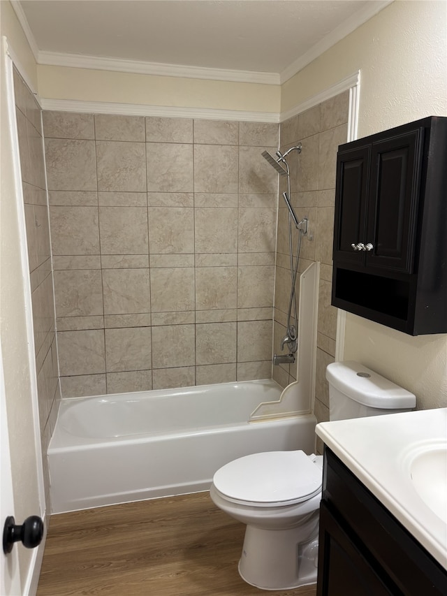 full bathroom featuring tiled shower / bath, wood-type flooring, vanity, toilet, and crown molding