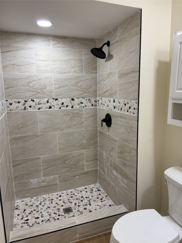 bathroom with toilet and tiled shower