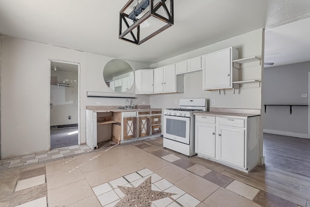 kitchen with white cabinetry, sink, white gas stove, and light tile patterned flooring