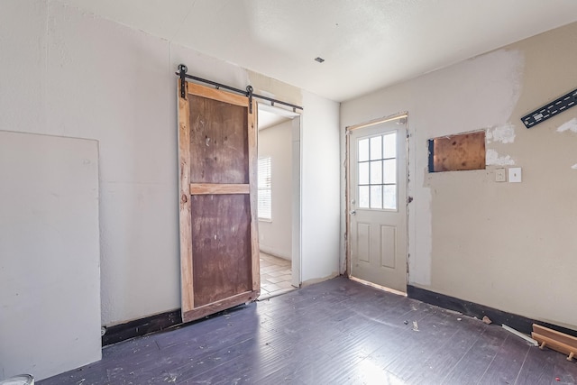 interior space with dark hardwood / wood-style flooring and a barn door