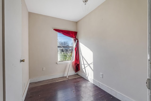 unfurnished room with dark wood-type flooring