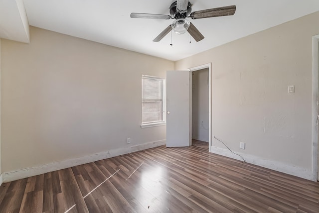 unfurnished room featuring dark wood-type flooring and ceiling fan