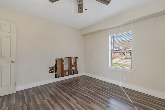 spare room featuring dark wood-type flooring and ceiling fan