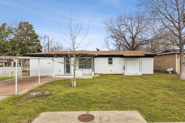 back of property featuring a carport and a lawn