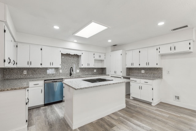 kitchen featuring white cabinetry, stainless steel dishwasher, black electric cooktop, and a kitchen island