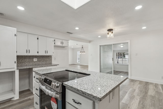 kitchen with white cabinetry, electric range, plenty of natural light, and tasteful backsplash