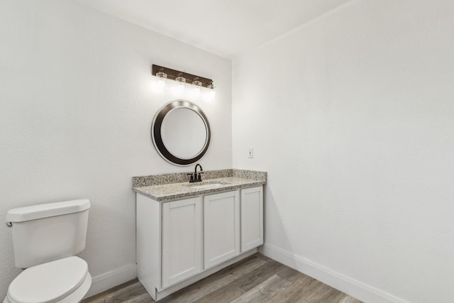 bathroom with vanity, wood-type flooring, and toilet