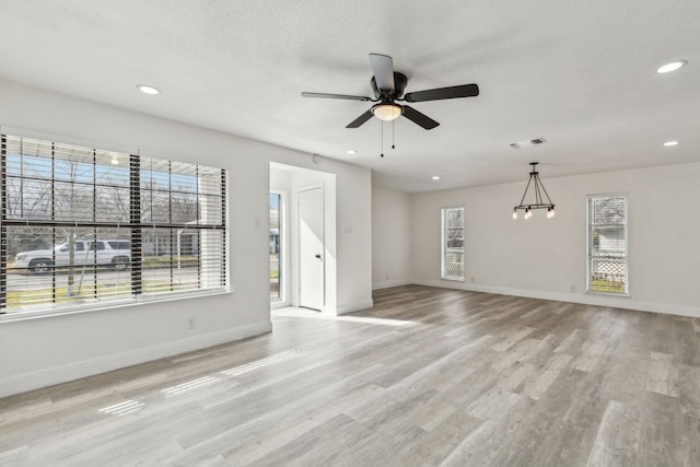 unfurnished living room featuring a textured ceiling, light hardwood / wood-style floors, and ceiling fan