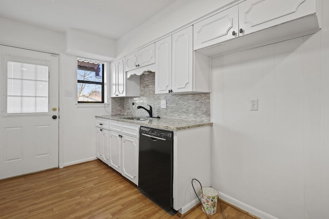 kitchen featuring dishwasher, sink, white cabinets, light stone counters, and light hardwood / wood-style floors