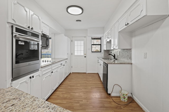 kitchen with white cabinetry, light stone countertops, and black appliances