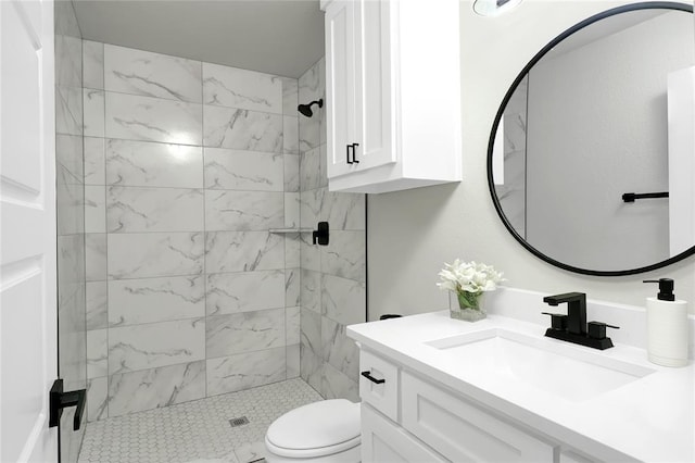 bathroom with vanity, toilet, and a tile shower