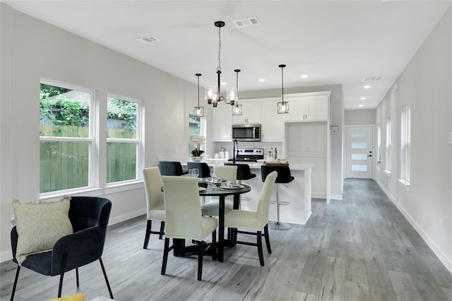 dining room with an inviting chandelier and light hardwood / wood-style floors