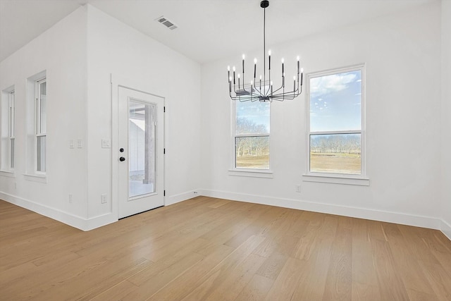 unfurnished dining area with light hardwood / wood-style flooring and a chandelier