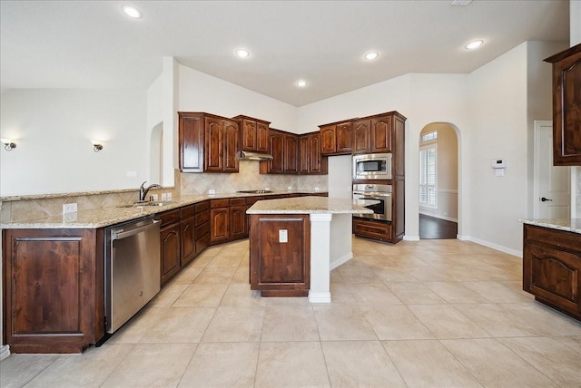 kitchen featuring light stone counters, appliances with stainless steel finishes, and a kitchen island