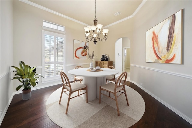 dining space featuring arched walkways, dark wood-type flooring, visible vents, baseboards, and crown molding