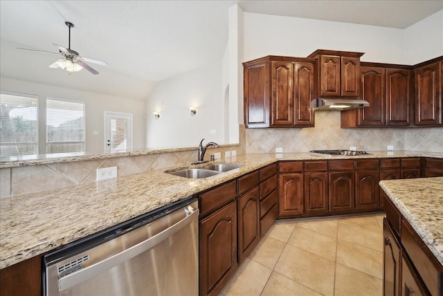 kitchen with lofted ceiling, sink, light tile patterned floors, stainless steel appliances, and light stone counters