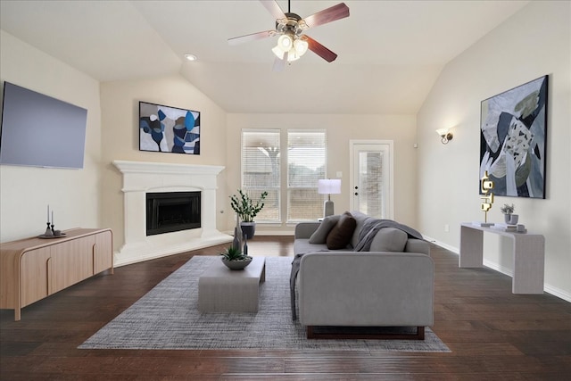 living room featuring dark wood-type flooring, ceiling fan, and vaulted ceiling