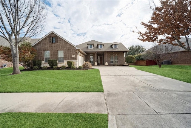 view of front of property with driveway, a garage, brick siding, central AC unit, and a front yard