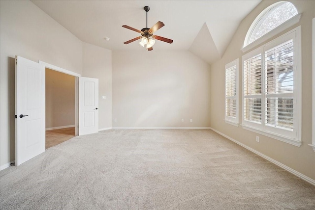 empty room with ceiling fan, lofted ceiling, and light carpet