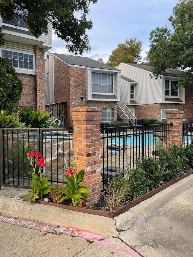 view of front of home with a fenced in pool