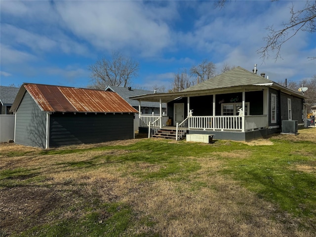 rear view of house featuring central AC, a lawn, and a porch