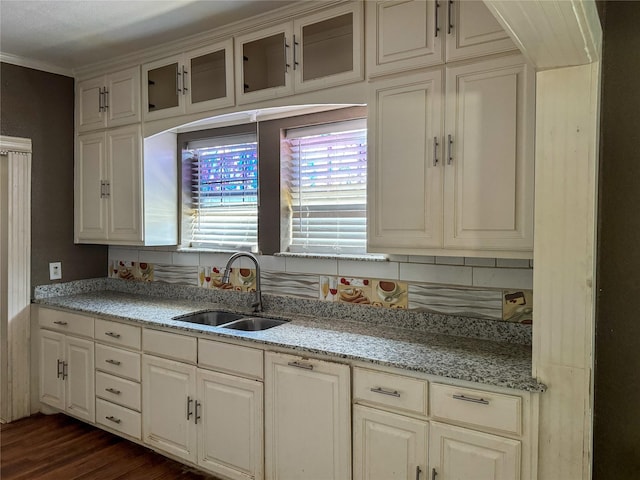 kitchen with dark hardwood / wood-style floors, tasteful backsplash, sink, and light stone counters