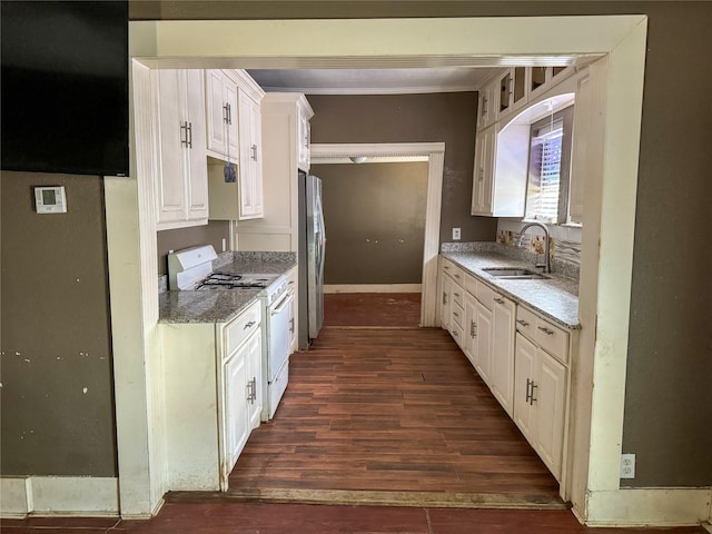 kitchen featuring sink, gas range gas stove, stainless steel refrigerator, white cabinetry, and dark hardwood / wood-style flooring