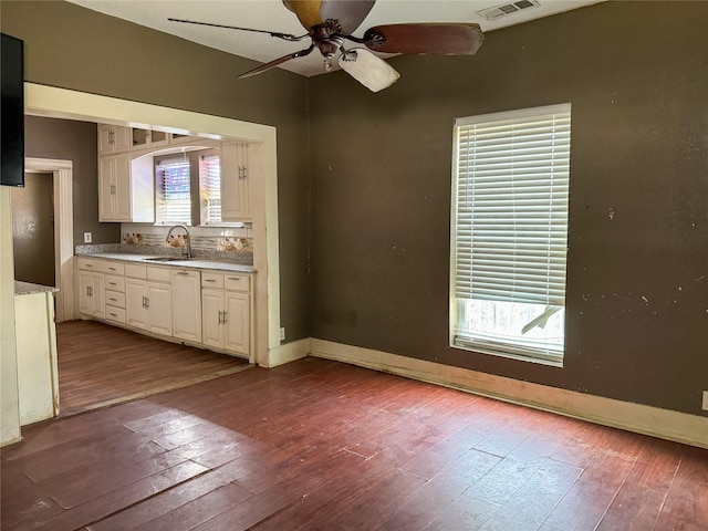 kitchen with sink, hardwood / wood-style floors, and white cabinets