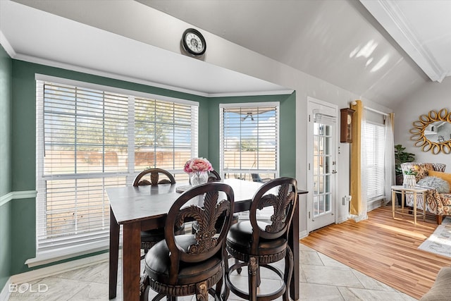 dining space with ornamental molding, lofted ceiling with beams, and light hardwood / wood-style flooring