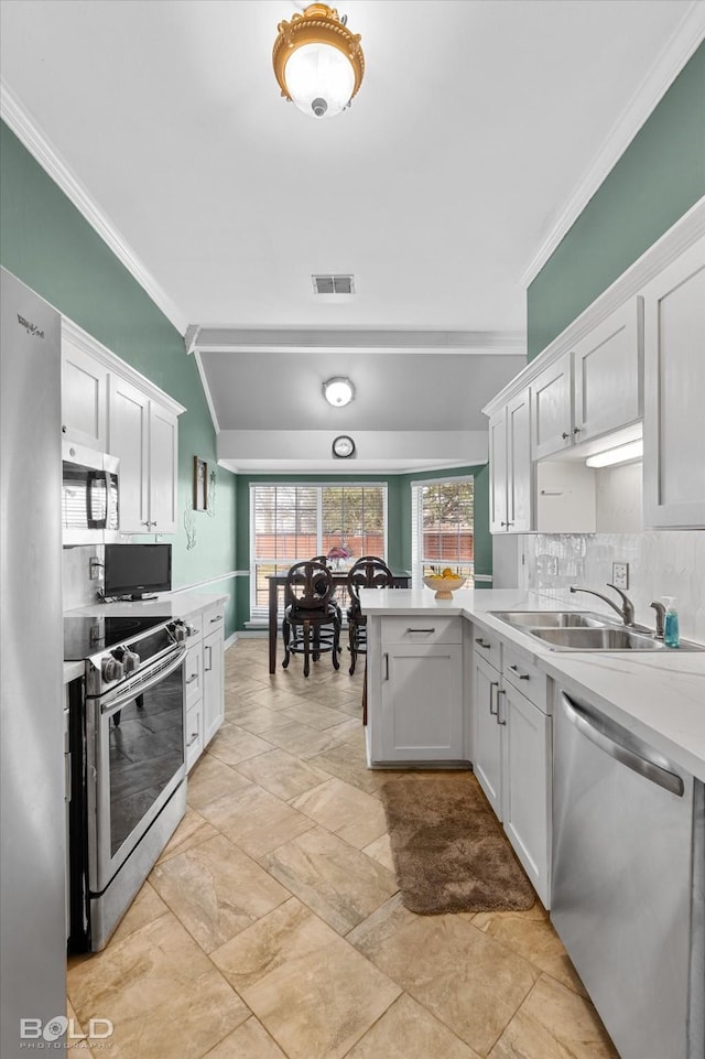 kitchen featuring crown molding, stainless steel appliances, and white cabinets