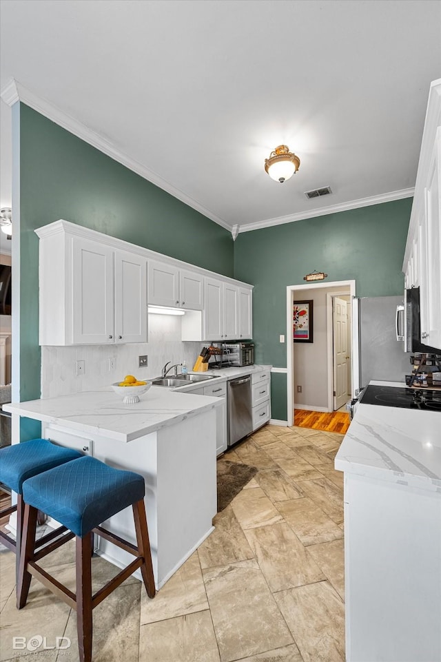 kitchen featuring stainless steel appliances, a breakfast bar, and white cabinets