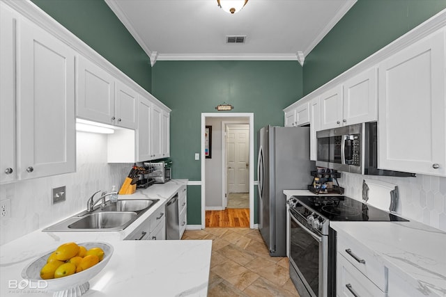 kitchen featuring appliances with stainless steel finishes, sink, white cabinets, and backsplash