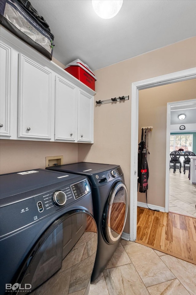 laundry room with independent washer and dryer and cabinets