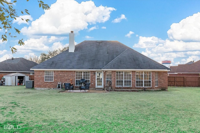 back of property featuring a shed, a patio area, a lawn, and central air condition unit