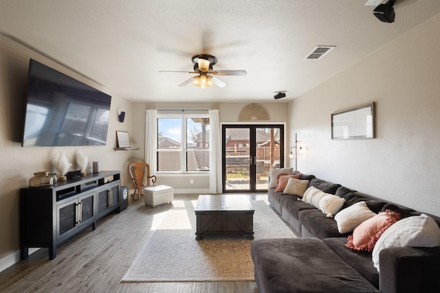 living room featuring wood-type flooring and ceiling fan