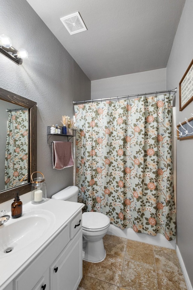 bathroom featuring vanity, toilet, and walk in shower